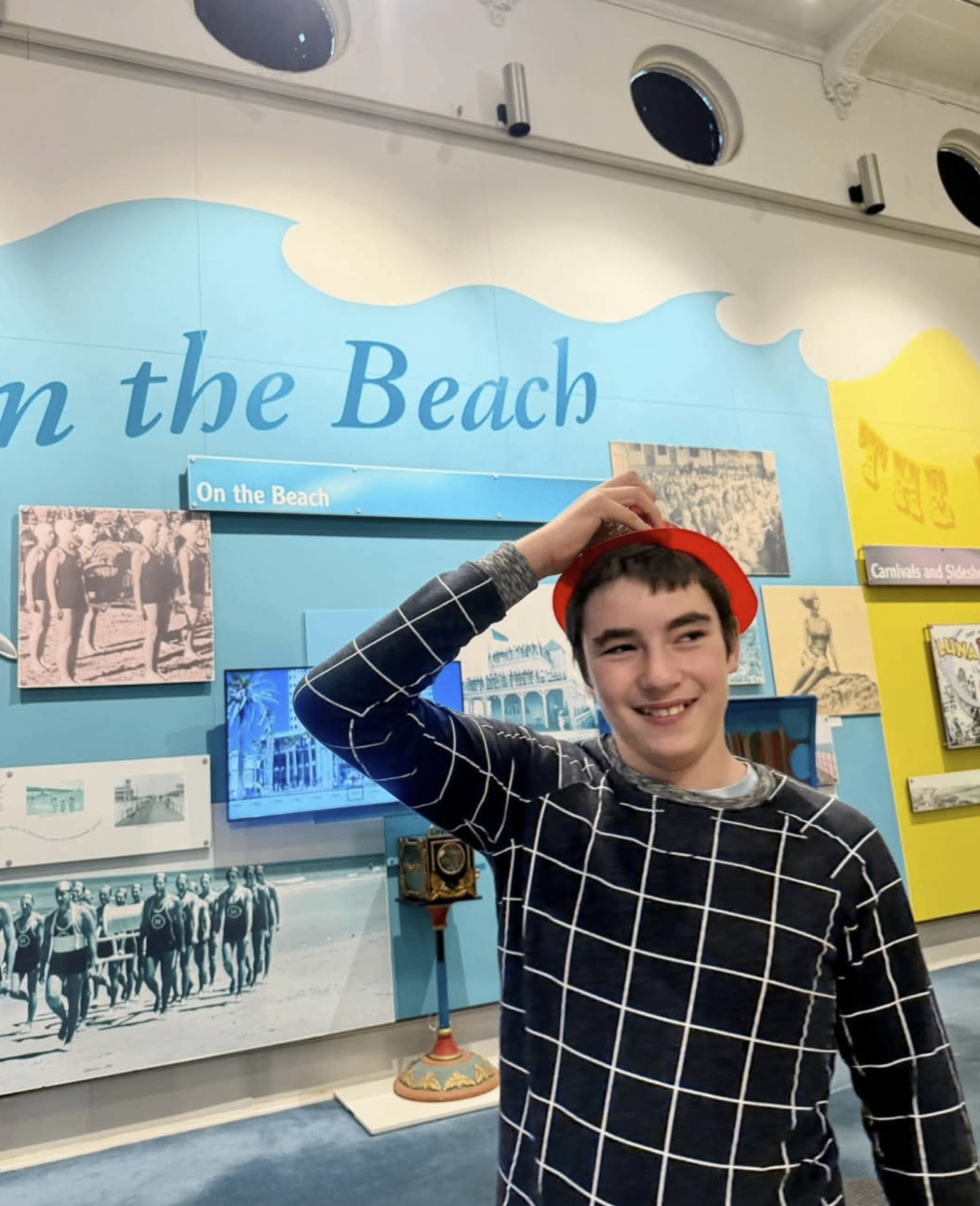 Older child smiling during a museum outing in Adelaide while exploring an interactive display