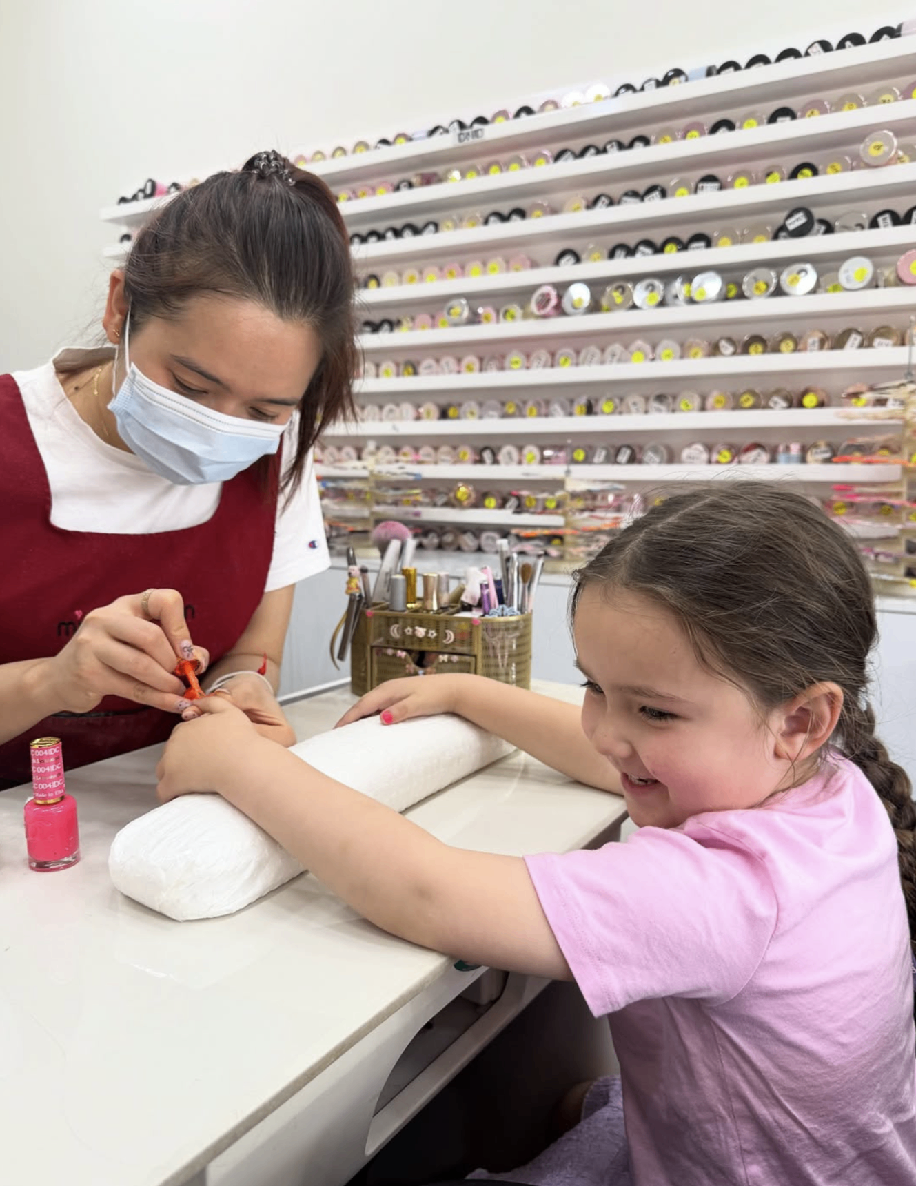 Child smiling while having nails painted during a supervised Adelaide community outing